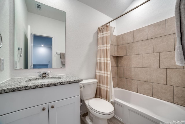 full bathroom featuring shower / bath combo, vanity, and toilet