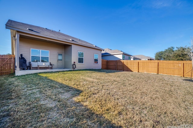 rear view of property with a yard and a patio