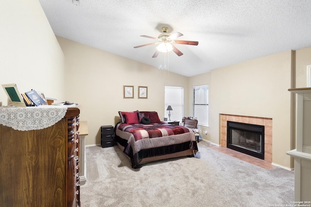 bedroom with vaulted ceiling, light colored carpet, a tile fireplace, and a textured ceiling