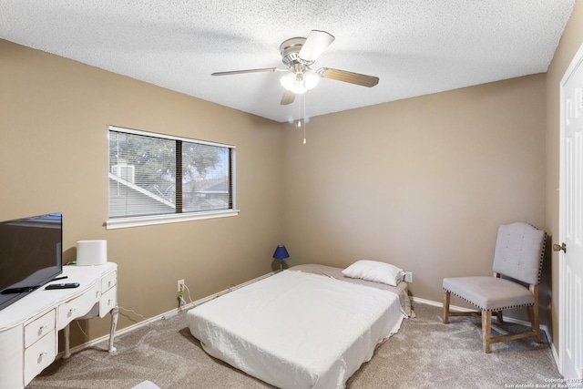 carpeted bedroom with ceiling fan and a textured ceiling