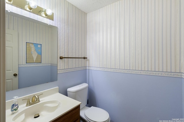 bathroom featuring vanity, toilet, and a textured ceiling