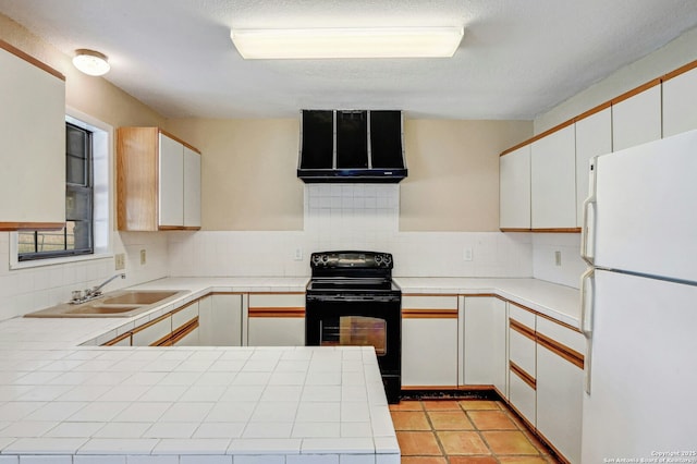 kitchen featuring electric range, tile counters, white refrigerator, kitchen peninsula, and white cabinets