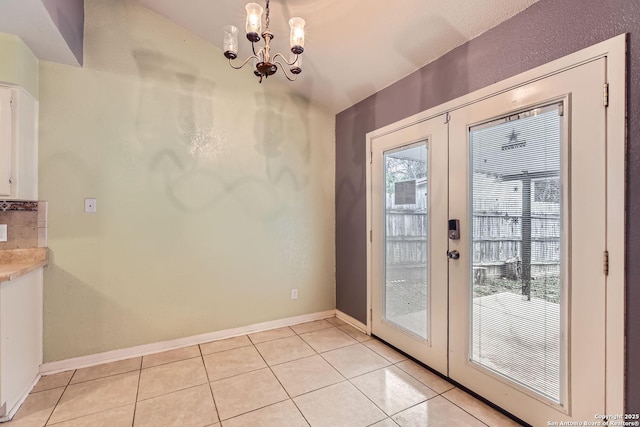 doorway to outside with french doors, a notable chandelier, and light tile patterned flooring