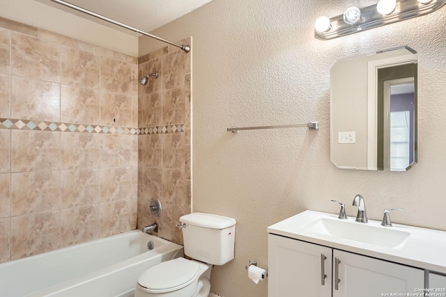 full bathroom featuring tiled shower / bath, vanity, and toilet