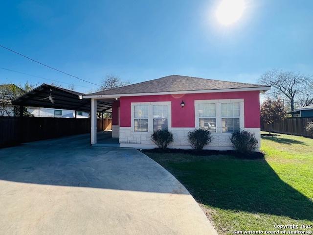 view of front of house with a front yard and a carport