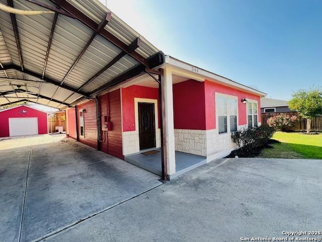 view of side of property with a garage, an outdoor structure, and a carport