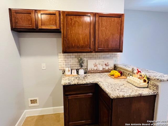 kitchen with light stone countertops and tasteful backsplash