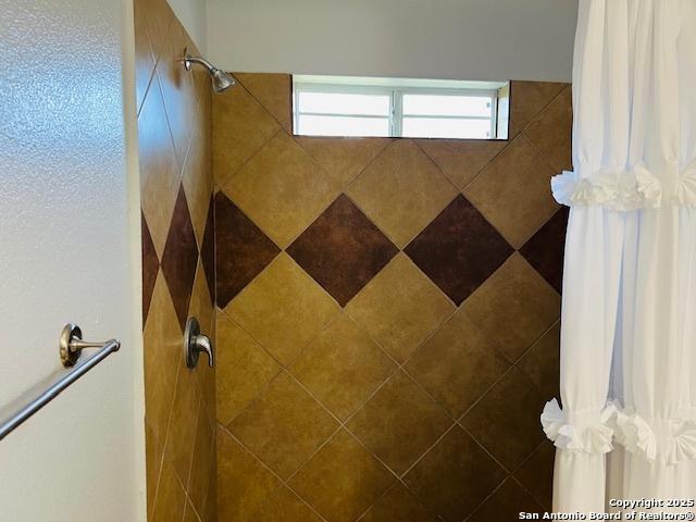 bathroom featuring a tile shower