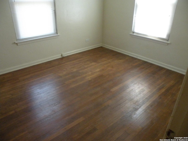 unfurnished room with a wealth of natural light and dark wood-type flooring