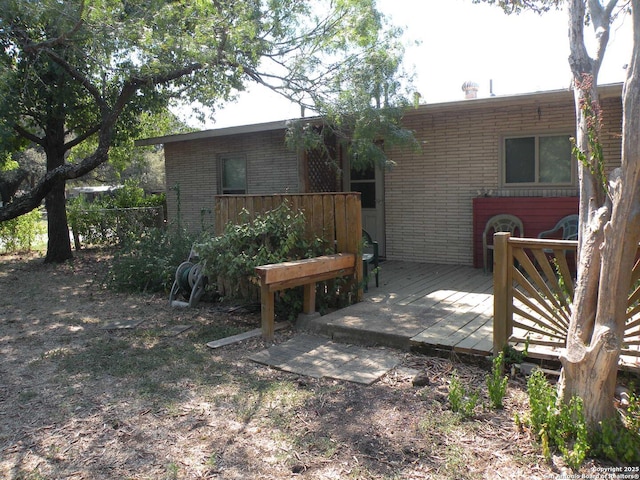 rear view of house featuring a wooden deck