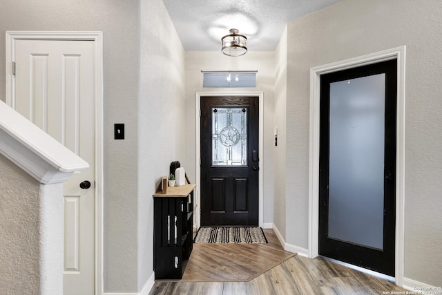 foyer featuring a textured ceiling and light wood-type flooring