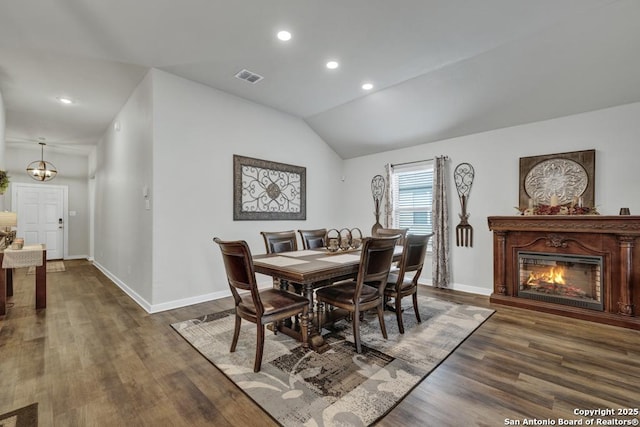 dining room with dark hardwood / wood-style flooring and lofted ceiling