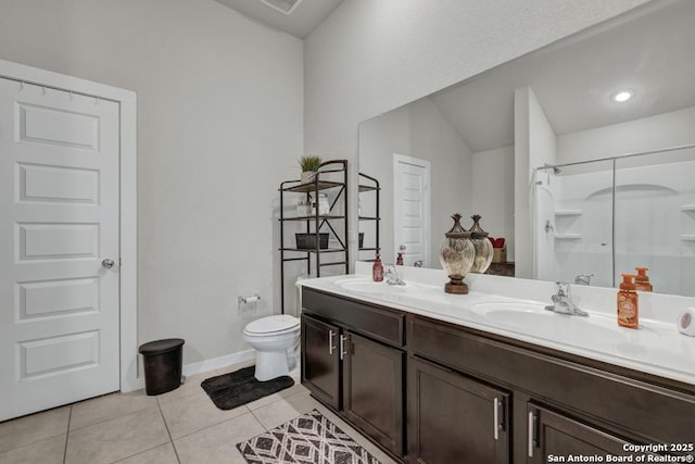 bathroom featuring tile patterned flooring, vanity, toilet, and walk in shower