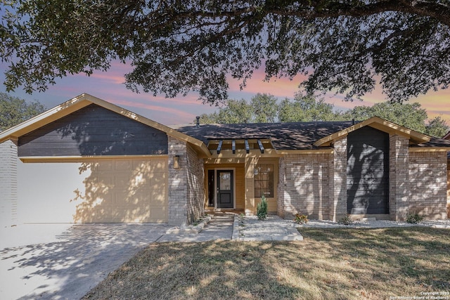 ranch-style house featuring a lawn and a garage