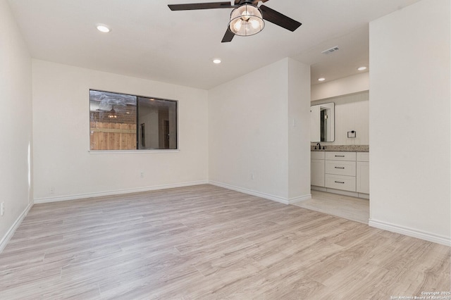 unfurnished room with ceiling fan and light wood-type flooring