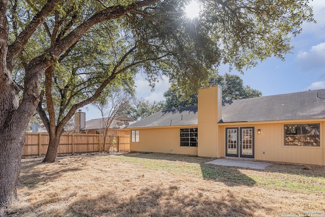 rear view of house with a yard and french doors