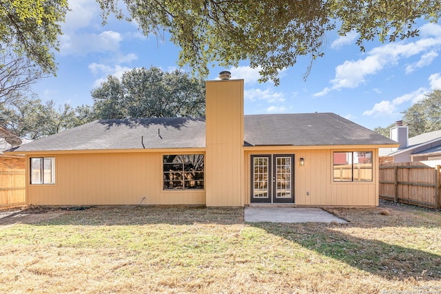 back of property with a lawn and a patio