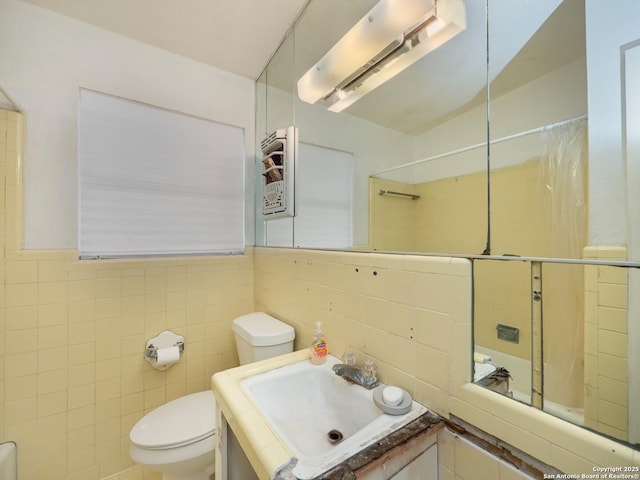 bathroom with vanity, toilet, tile walls, and walk in shower