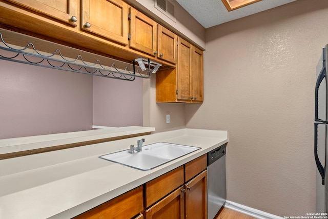 kitchen with sink, a textured ceiling, and appliances with stainless steel finishes