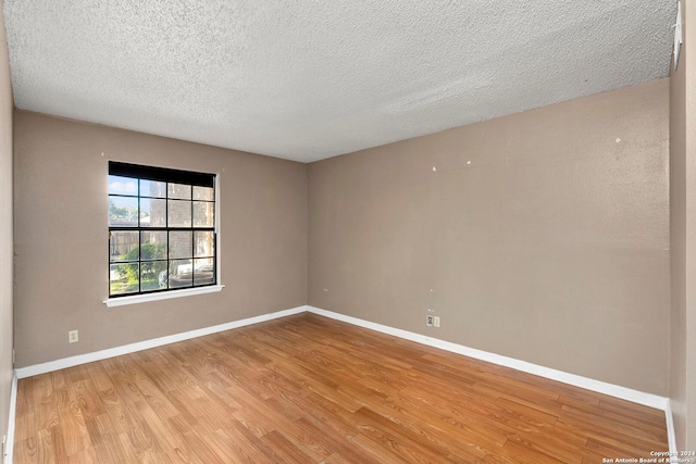 unfurnished room with light hardwood / wood-style floors and a textured ceiling