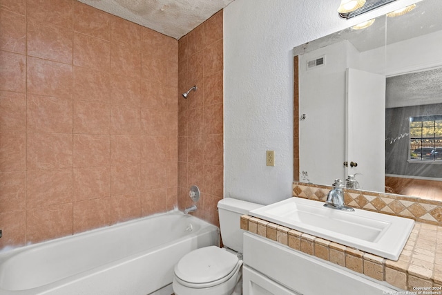 full bathroom with vanity,  shower combination, toilet, and a textured ceiling