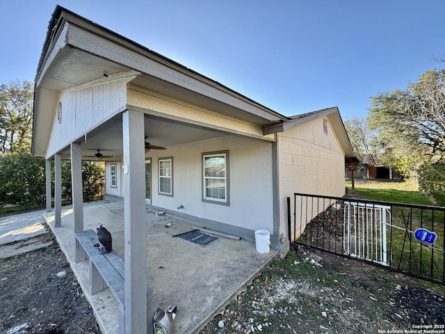 view of side of property with ceiling fan and a patio