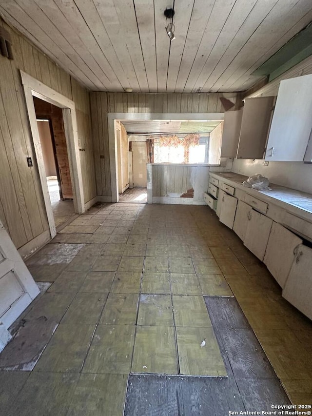 kitchen featuring wood ceiling and wood walls