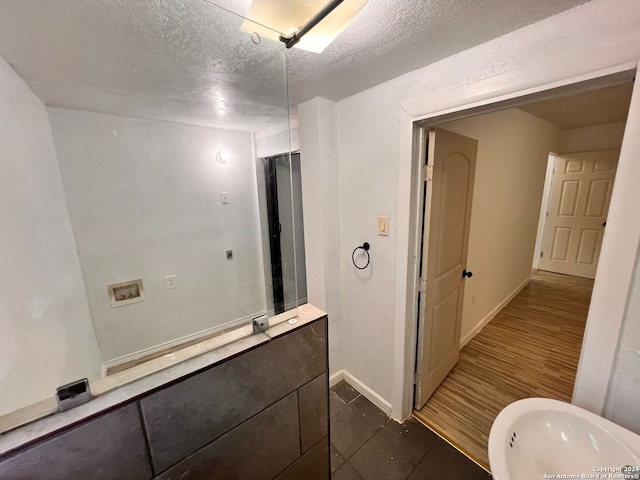 bathroom with a textured ceiling and hardwood / wood-style flooring