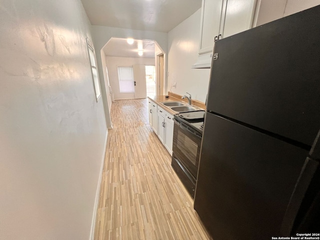 kitchen with sink, white cabinets, fridge, and black range with electric cooktop