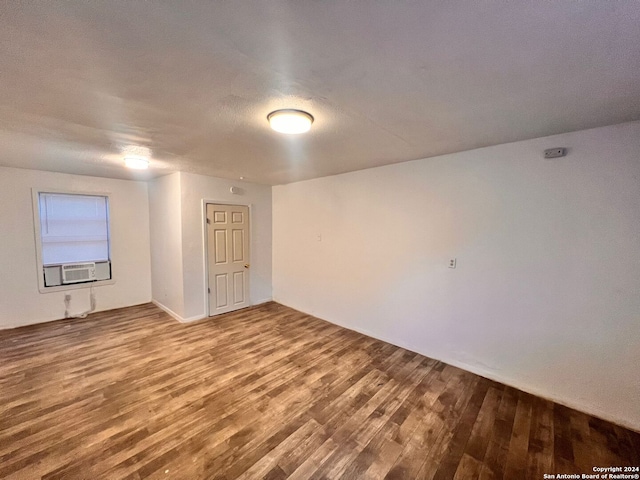 spare room with cooling unit, wood-type flooring, and a textured ceiling