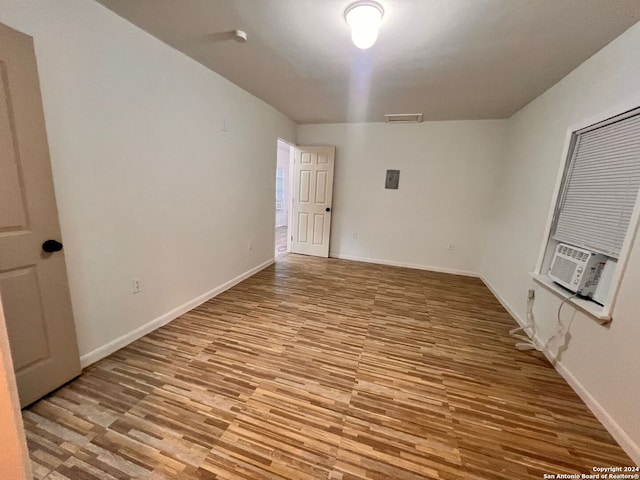 spare room featuring cooling unit and light hardwood / wood-style flooring