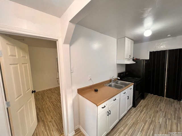 kitchen featuring white cabinets, light hardwood / wood-style floors, black electric range, and sink