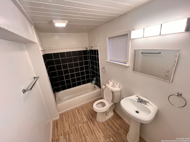 full bathroom featuring sink, toilet, wood-type flooring, and tub / shower combination