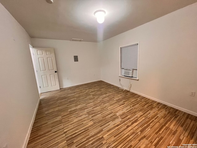 empty room featuring hardwood / wood-style floors and cooling unit