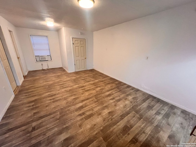 unfurnished room with cooling unit and dark hardwood / wood-style floors