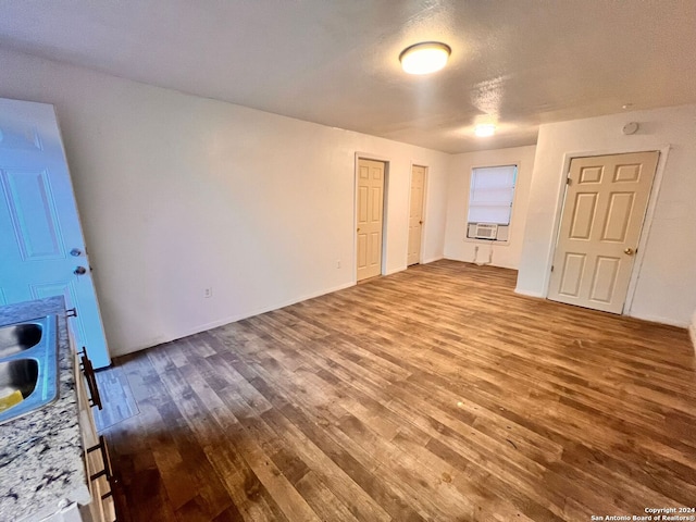 spare room featuring hardwood / wood-style floors, cooling unit, and a textured ceiling