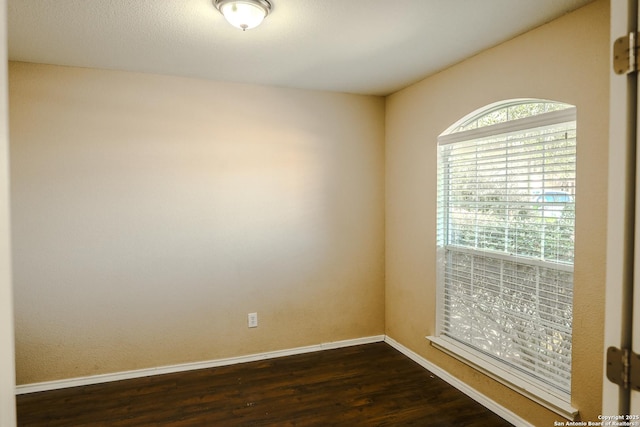 empty room with dark hardwood / wood-style flooring