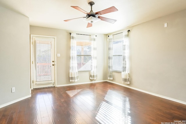 empty room with ceiling fan, a healthy amount of sunlight, and dark hardwood / wood-style flooring