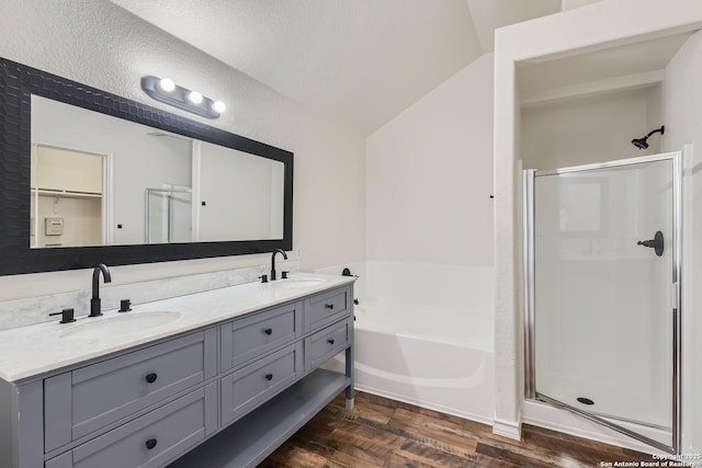 bathroom with vanity, wood-type flooring, lofted ceiling, and shower with separate bathtub