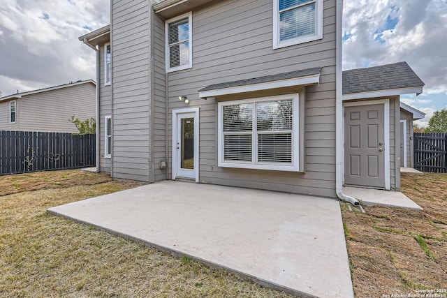 back of house featuring a lawn and a patio