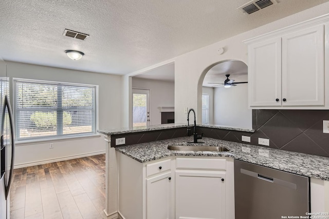 kitchen with decorative backsplash, stainless steel dishwasher, ceiling fan, sink, and white cabinets