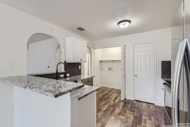 kitchen featuring white cabinets, sink, light stone countertops, a textured ceiling, and stainless steel appliances