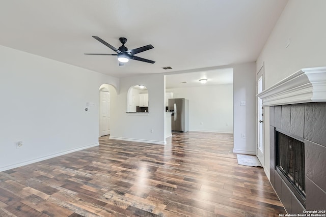 unfurnished living room featuring ceiling fan and dark hardwood / wood-style floors