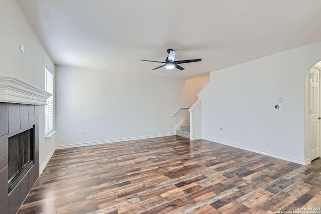 unfurnished living room with a fireplace, dark hardwood / wood-style floors, and ceiling fan