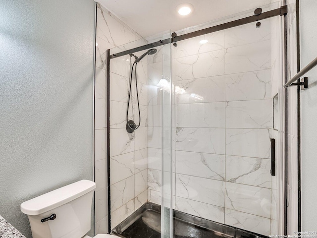 bathroom with an enclosed shower and toilet