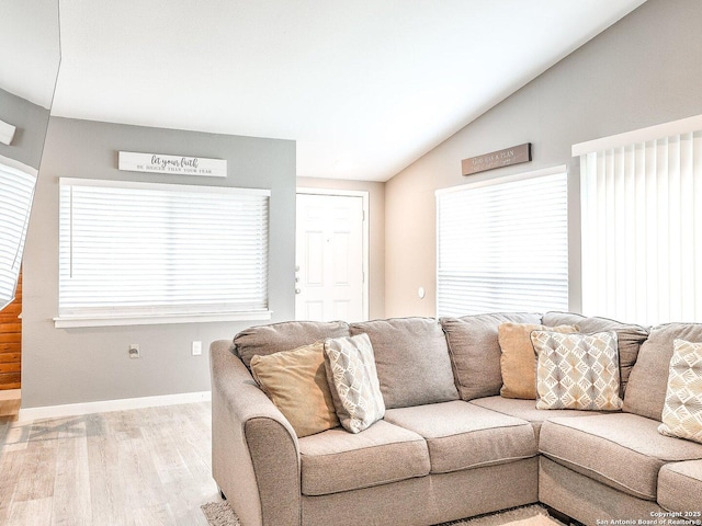 living room with light hardwood / wood-style floors and vaulted ceiling