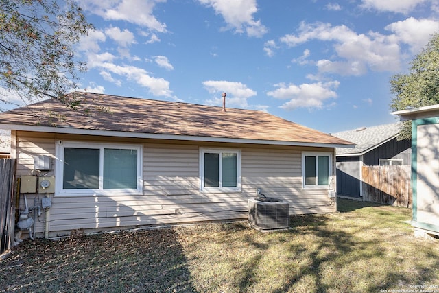 rear view of house featuring a lawn and cooling unit