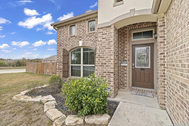 view of exterior entry with a lawn