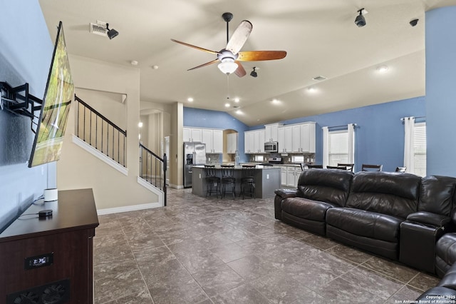 living room with ceiling fan and vaulted ceiling