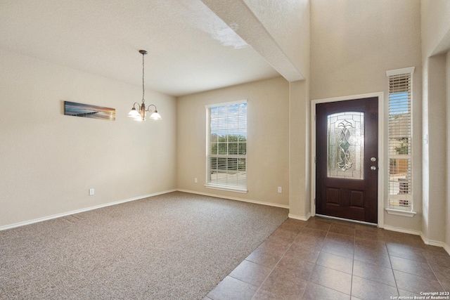 foyer featuring carpet and a chandelier